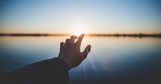 letting-go-of-the-past-hand-reaching-sun